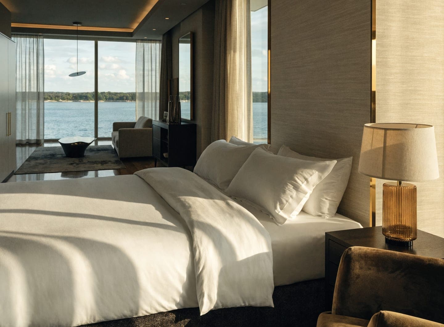 Sunlit luxury hotel suite with a view over the water